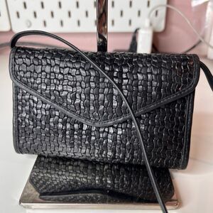 Casleigh New York black vintage woven leather crossbody bag with a flap closure